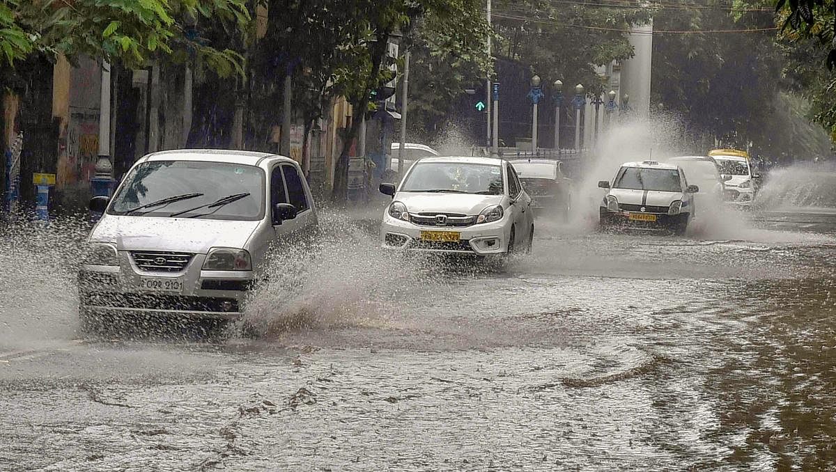 Vehicles drive on a waterlogged road after rainfall, in Kolkata on Sunday. PTI photo