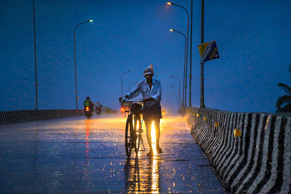 Kanyakumari: A man walks along a road with his bicycle during pre-Monsoon showers at Nagercoil in Kanyakumari district, Monday, June 10, 2019. (PTI Photo)