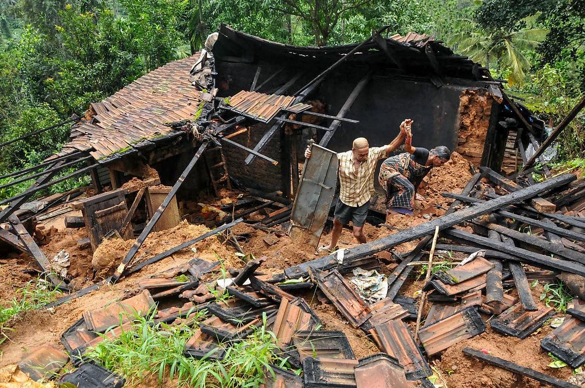 Residents collect materials and belongings from their damaged house in a flood affected area near Mudigere in Chikmagalur district, Monday, Aug 19, 2019. (PTI Photo)