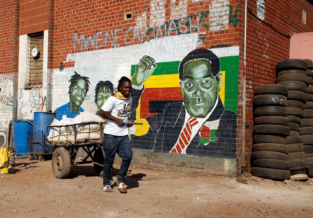 A youth pushes a cart loaded with maize for sale nearby a mural depicting Zimbabwe's former President Robert Mugabe, after hearing the news of his death, in Mbare in the capital Harare, Zimbabwe, September 6, 2019. REUTERS/Philimon Bulawayo