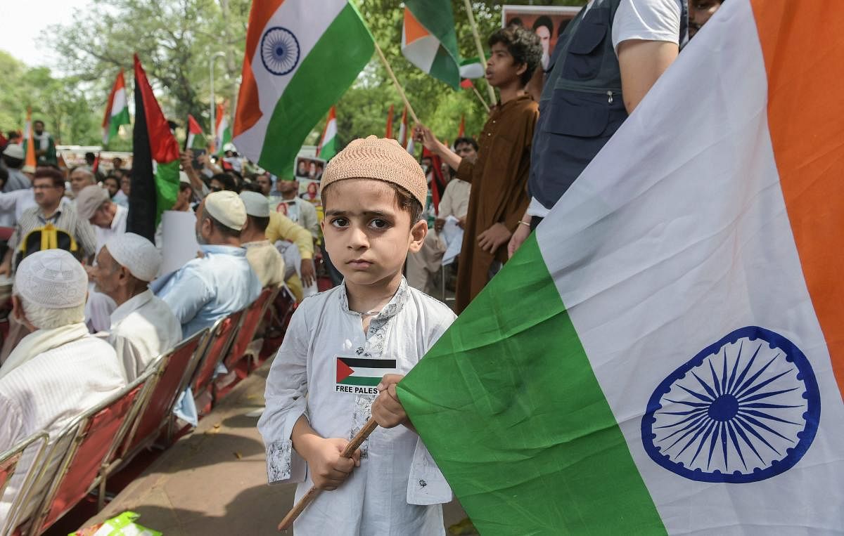 A Child holds a tricolour during a protest organized by Majlis-e-Ulama-e-Hind in solidarity with Palestinian people and demanded the liberation of Jerusalem's holy Al-Aqsa Mosque, at Jantar Mantar, in New Delhi, on Friday. PTI Photo