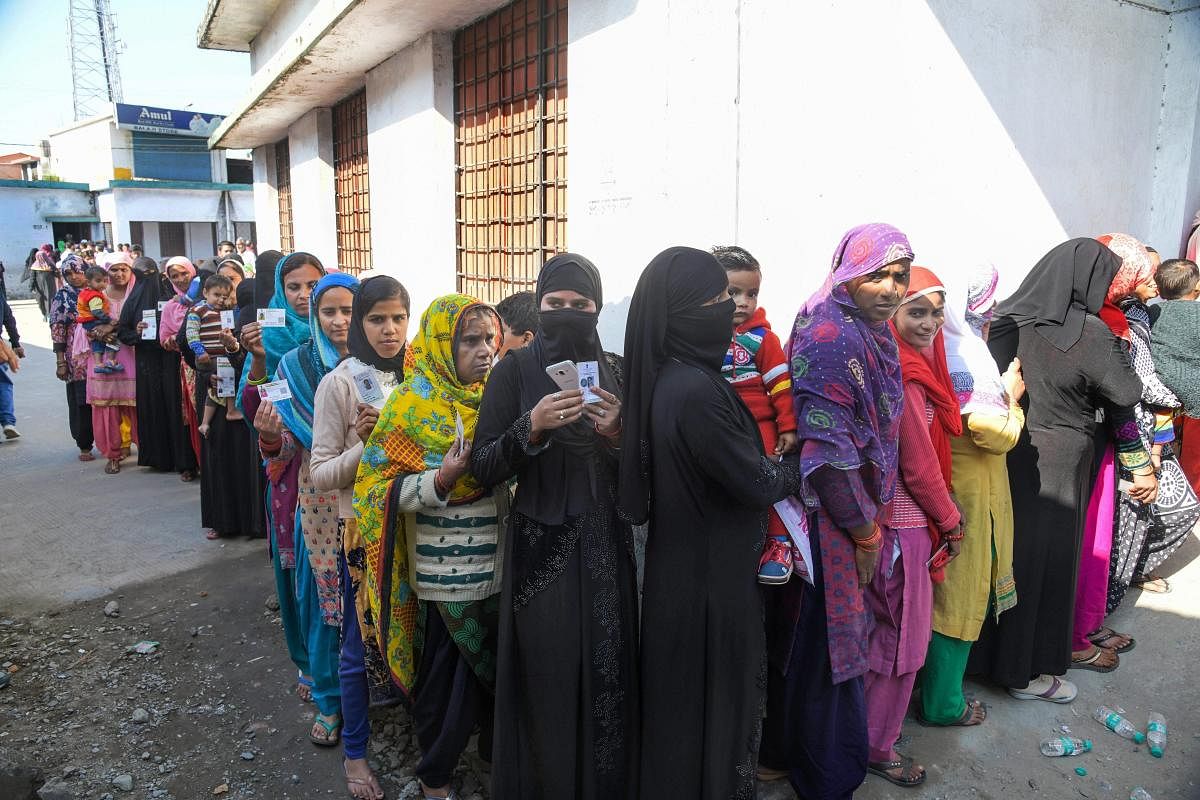 Muslim women stand in a long queue to cast their votes for local body elections in Dehradun, Sunday. PTI photo