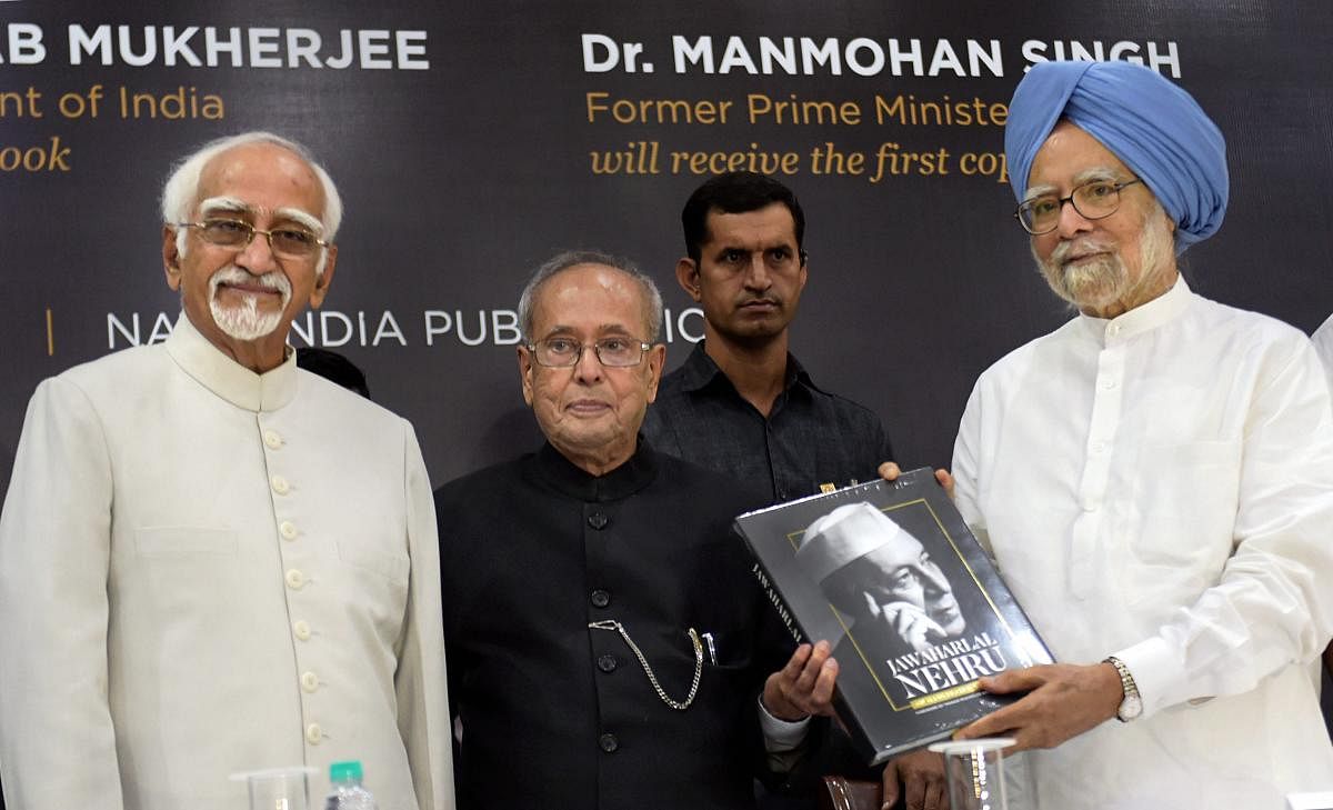 Former prime minister Manmohan Singh receives the first copy of the book from former president Pranab Mukherjee as former vice president Hamid Ansari looks on, during the book launch of 'Jawaharlal Nehru' an illustrated biography by A Gopanna, in New Delhi, on Sunday. PTI Photo