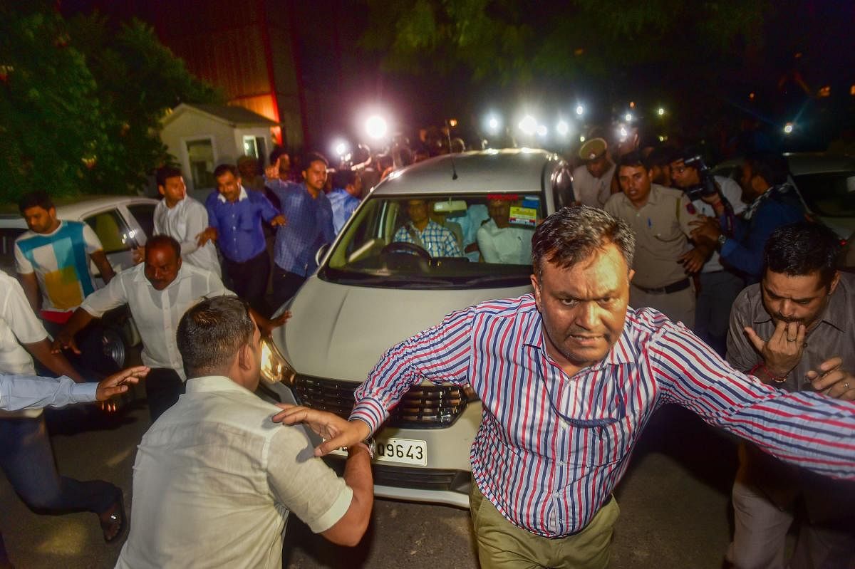 An official clears the way for the vehicle in which Central Bureau of Investigation (CBI) officials escorted Congress leader P Chidambaram after his arrest from his Jor Bagh residence in New Delhi, Wednesday, Aug 21, 2019. (PTI)