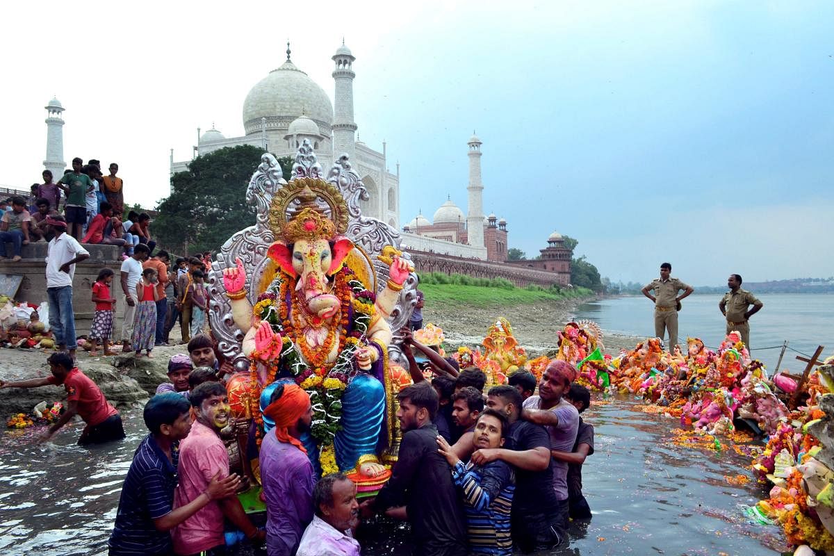 Agra: Devotees immerse an idol of Lord Ganesha in the Yamuna river on the banks of the Taj Mahal, in Agra, Sunday, Sept 23, 2018. (PTI Photo)