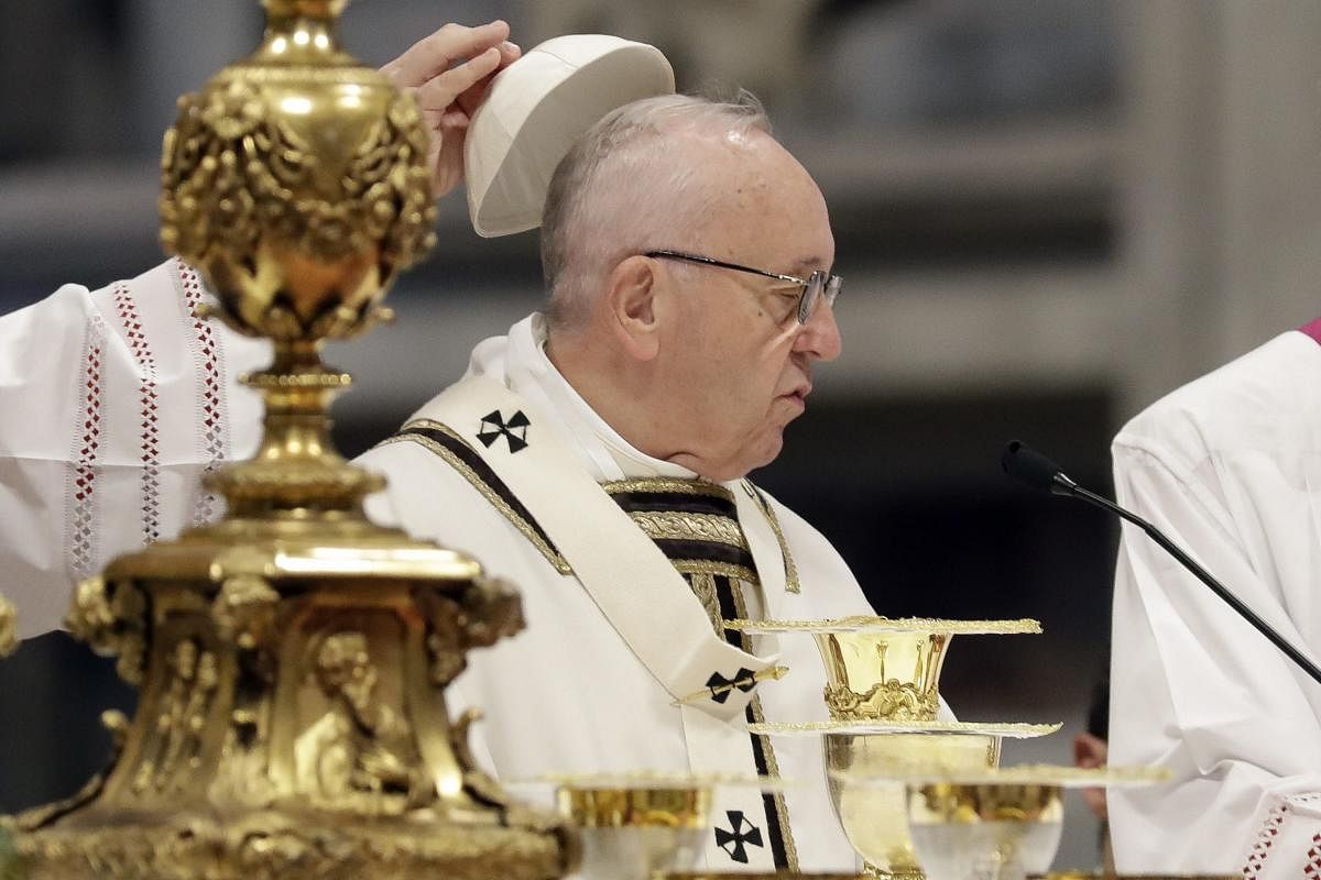 Pope Francis has his cap removed as he celebrates a mass in St. Peter basilica at the Vatican, Sunday. AP/PTI Photo