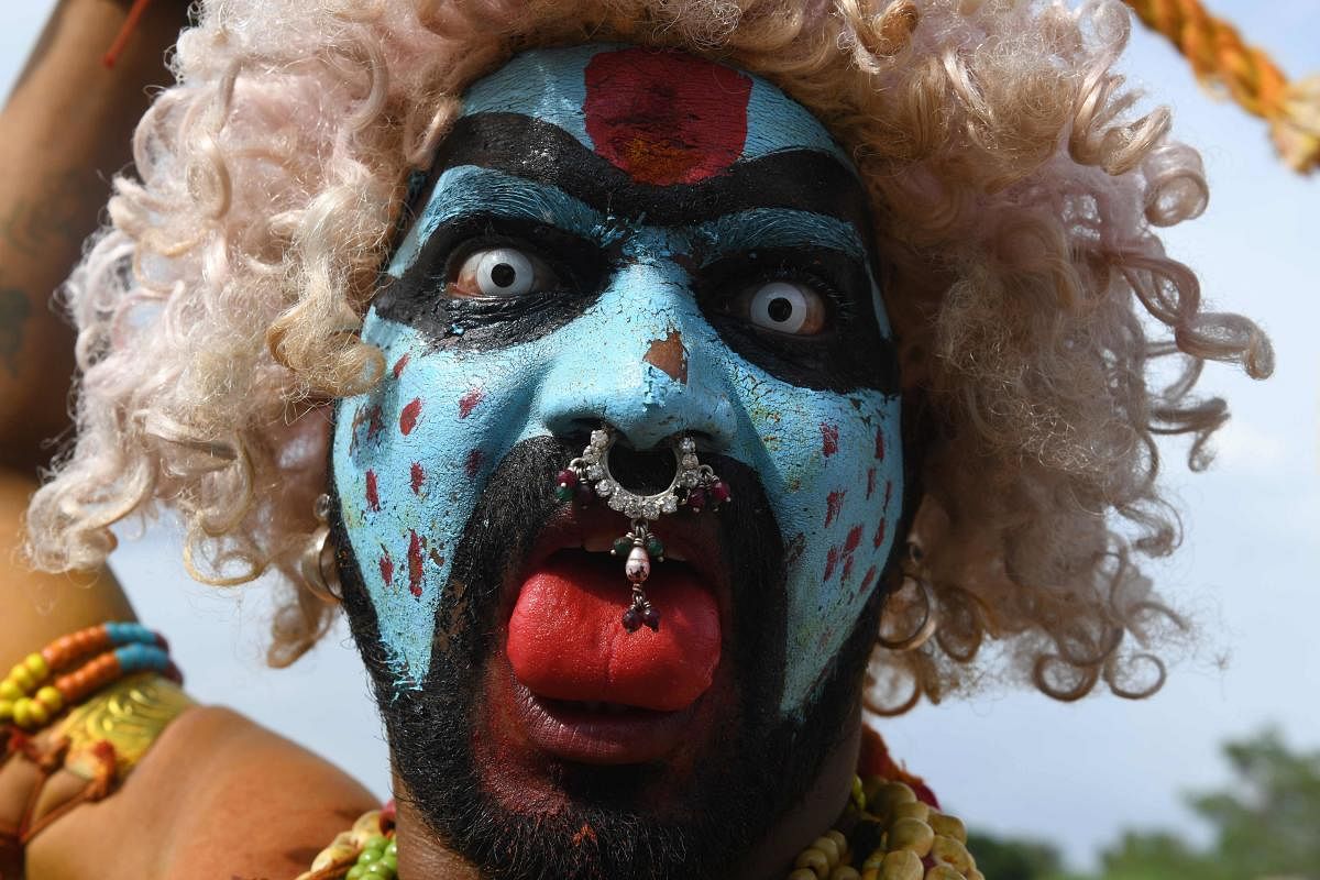 An Indian Hindu devotees representing Potharaju, brother of the goddess Mahankali, gestures during the festival of Bonalu, a ritual offering to the goddess Kali, at Golkonda Fort in Hyderabad. (AFP Photo)