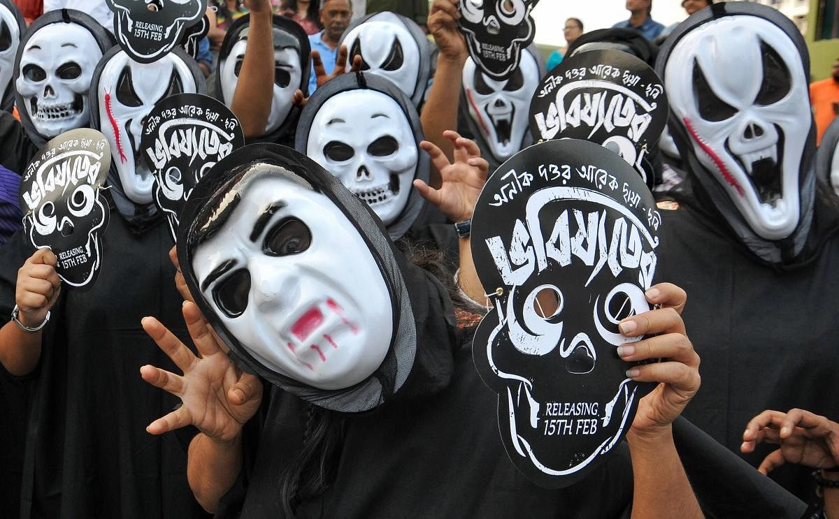Kolkata: Film enthusiasts wear masks as they take to the streets against bar on screening of 'Bhobisyoter Bhoot' (Future Ghosts), a political satire, at cinema halls, in Kolkata, Sunday, March 10, 2019. (PTI Photo)