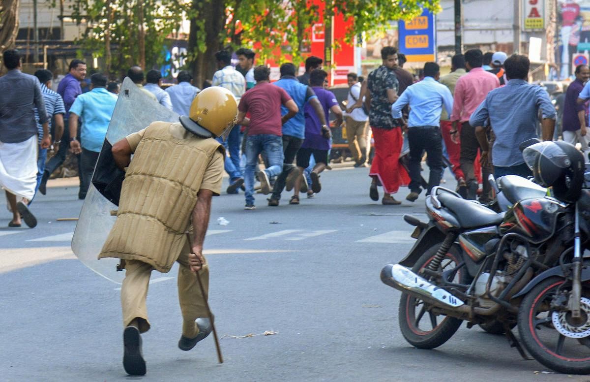 A policeman chases away protesters during a protest against the entry of two women to the Sabarimala temple, in Thiruvananthapuram. PTI