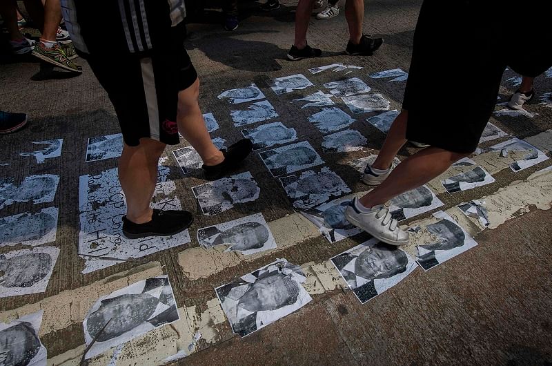 Protesters walk on an image of Chinese President Xi Jinping in the Causeway Bay area in Hong Kong. (AFP)