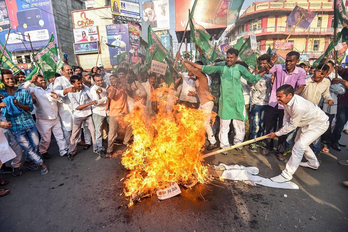 RJD supporters burn an effigy during a protest against steep hike in prices of fuel and other essential commodities, in Patna on Saturday. PTI Photo