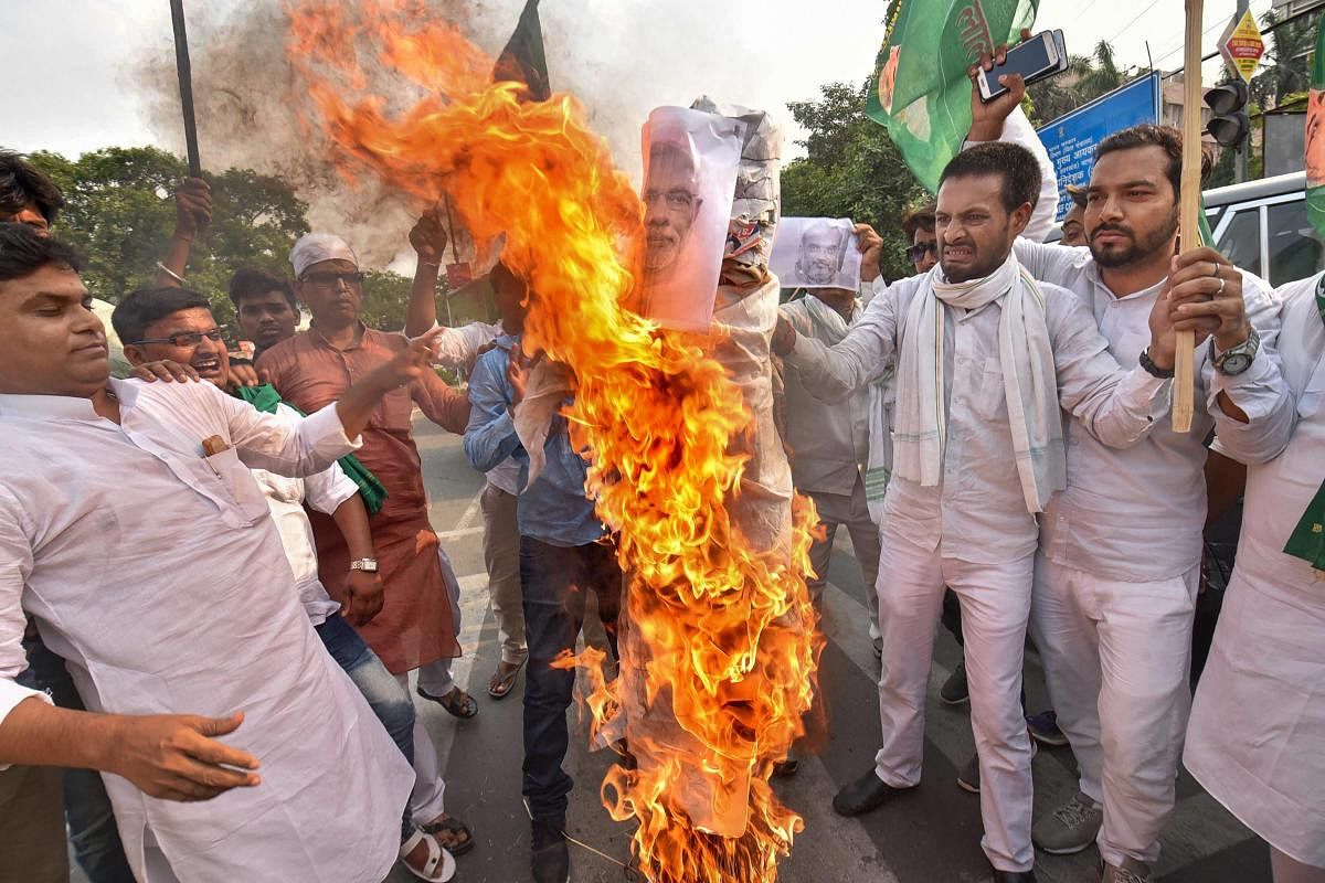 Youth RJD activists burn an effigy during a protest against hike in the prices of fuel and other essential commodities, in Patna, on Friday. PTI Photo