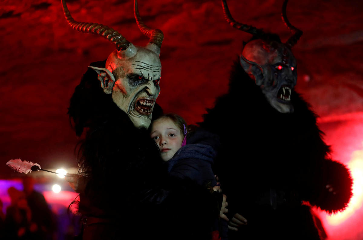 A man dressed as a devil embraces a child as part of a tradition to determine if she had behaved well during the past year, inside of a sandstone cave in the village of Svitava near the town of Cvikov, Czech Republic. Reuters.