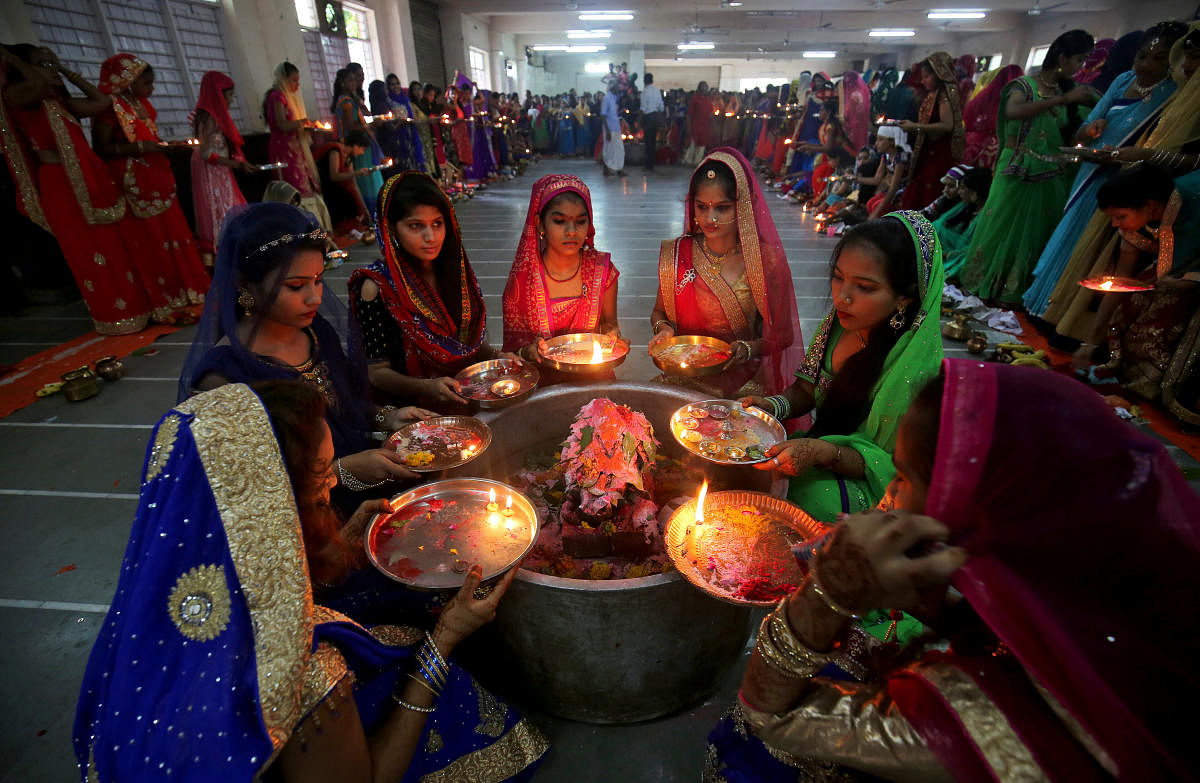 Hindu women perform a ritual known as Aarti around a Shivling (a symbol of Lord Shiva) on the last day of Jaya Parvati Vrat festival, in Ahmedabad, India, July 29, 2018. REUTERS/Amit Dave