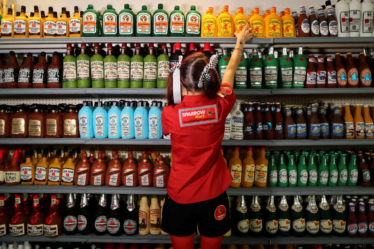 British artist Lucy Sparrow, 32, adjusts bottles of alcohol on shelves in her art installation supermarket in which everything is made of felt, in Los Angeles, California, U.S. July 31, 2018. REUTERS/Lucy Nicholson