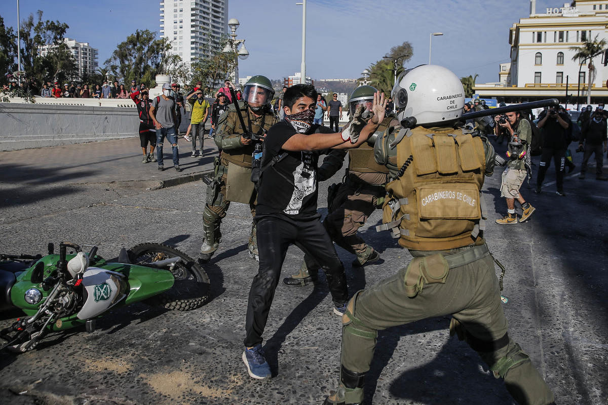 A demonstrator struggles with a riot police during clashes which erupted in a protest against Chile's President Sebastian Pinera in the country's seaside resort of Vina del Mar. (AFP Photo)