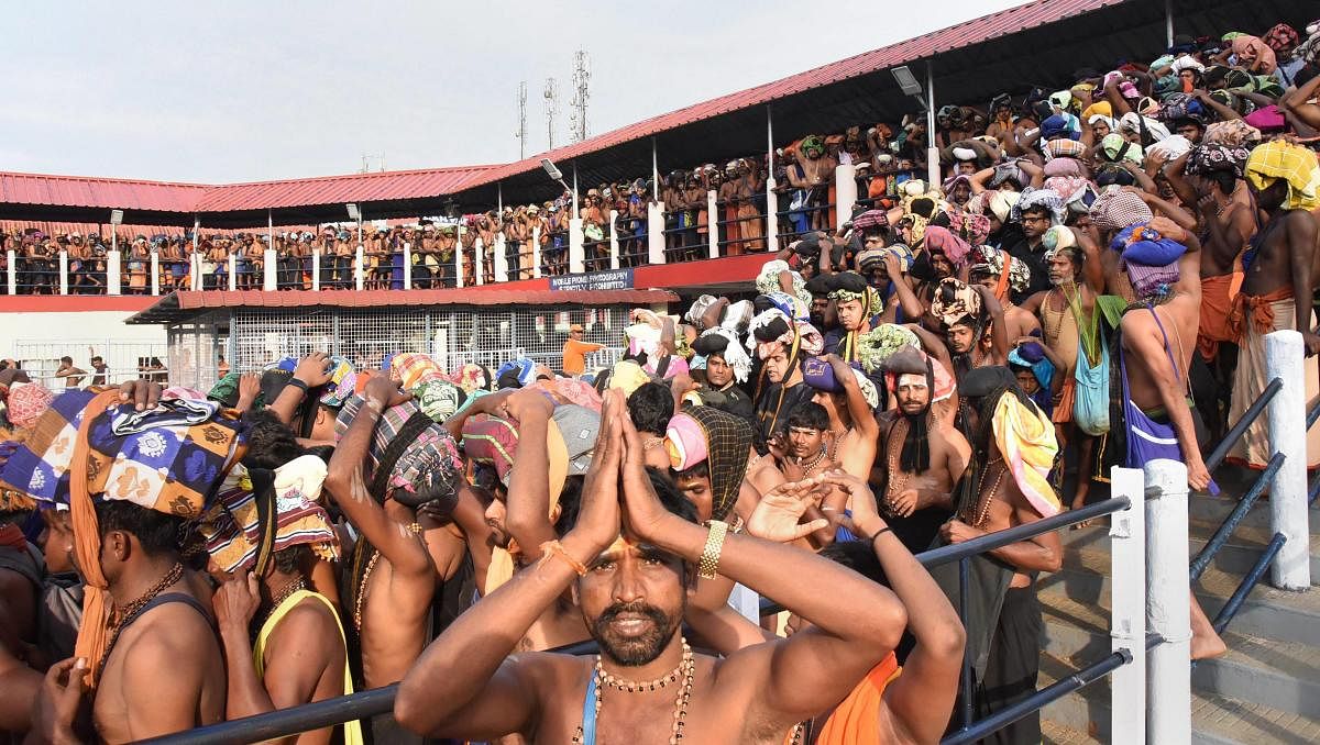 Devotees wait to offer prayers at Lord Ayyappa temple on the first day of Malayalam month of 'Vrischikom in Sabarimala on  Saturday. PTI