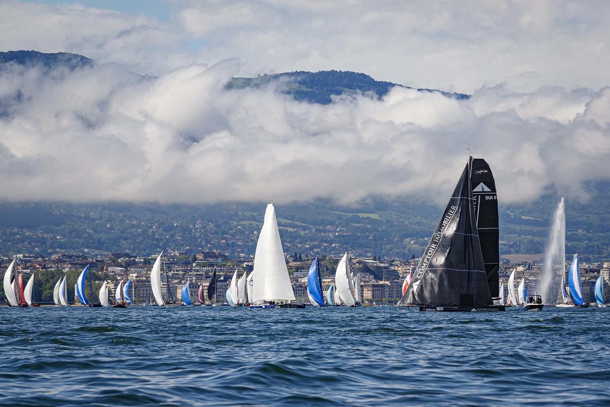 Sailboats line up on the starting line in front of the Geneva fountain (Jet d'eau de Geneve, in French) during the 81st