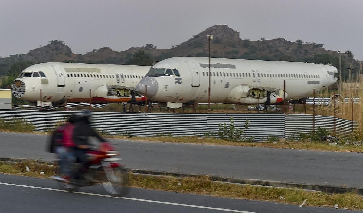 Behror: A biker rides past scrapped passenger planes lying at a yard of a scrap-dealer in Behror, Rajasthan, Friday, Nov 23, 2018. The dealer bought the planes to convert them into restaurants. (PTI Photo/Kamal Kishore)