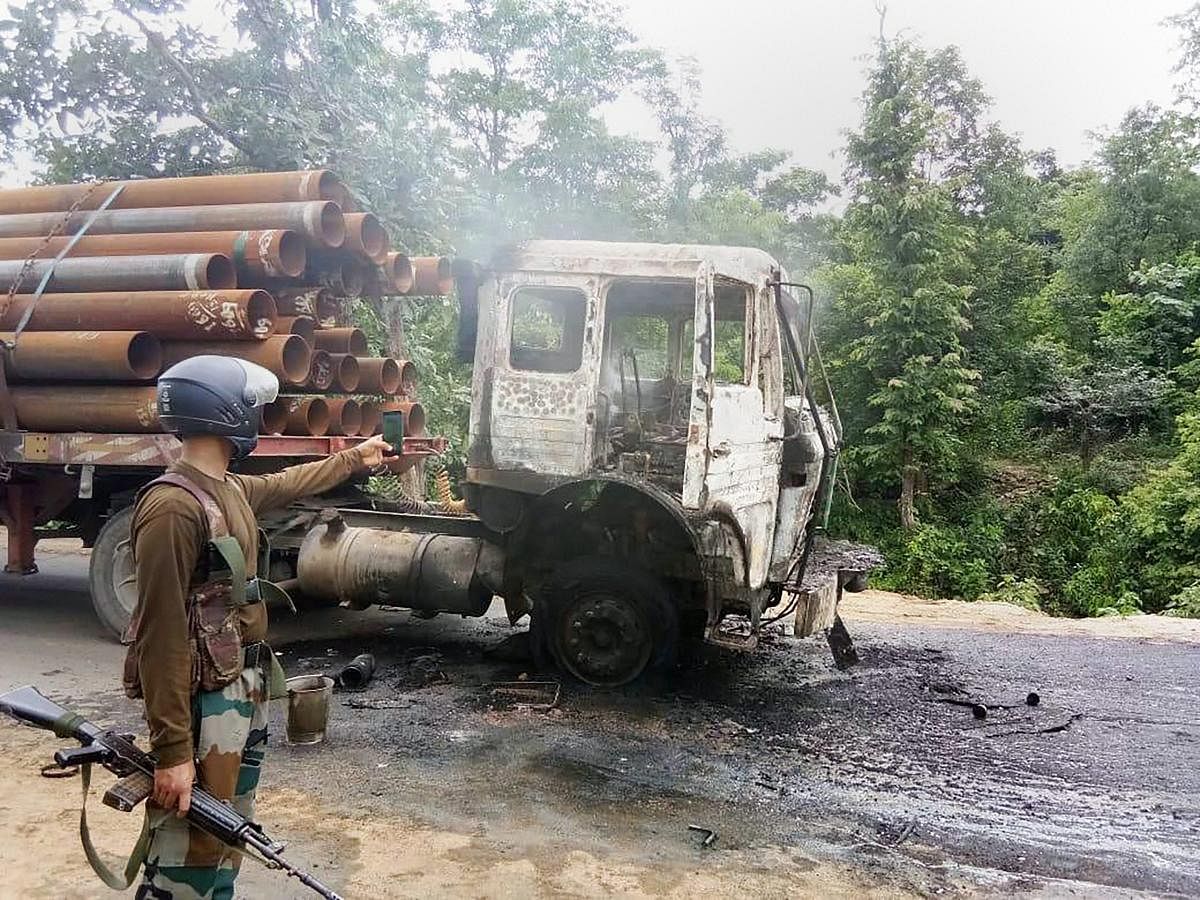A security person takes pictures of a truck that was torched by the Maoists at Ranchi-Tata highway during their Jharkhand bandh, in Ranchi on Friday. PTI Photo