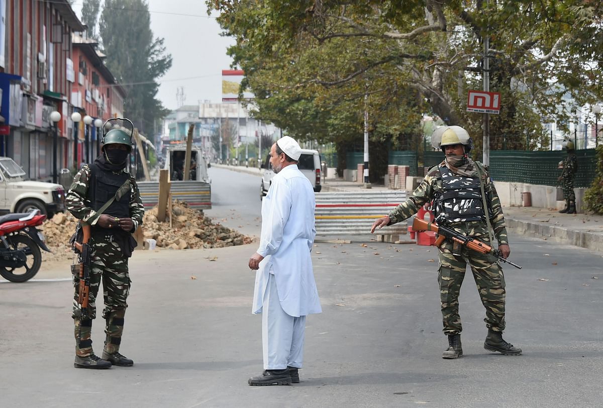 Security personnel stand guard on a road leading to Lal Chowk during restrictions in Srinagar. (PTI)