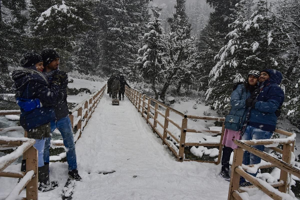 A tourist family enjoys during fresh snowfall at Gagangir in Ganderbal district of central Kashmir, Wednesday, Jan 2, 2019. Kashmir received its first snowfall of the New Year, breaking a month-long dry spell in the Valley. PTI