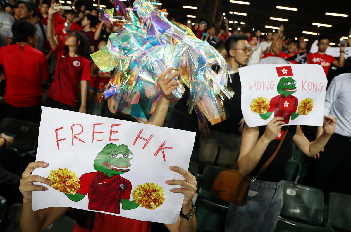 Soccer fans hold placards in support of anti-government protesters during a football World Cup qualifier match between Hong Kong and Iran, at Hong Kong Stadium. (Photo by Reuters)