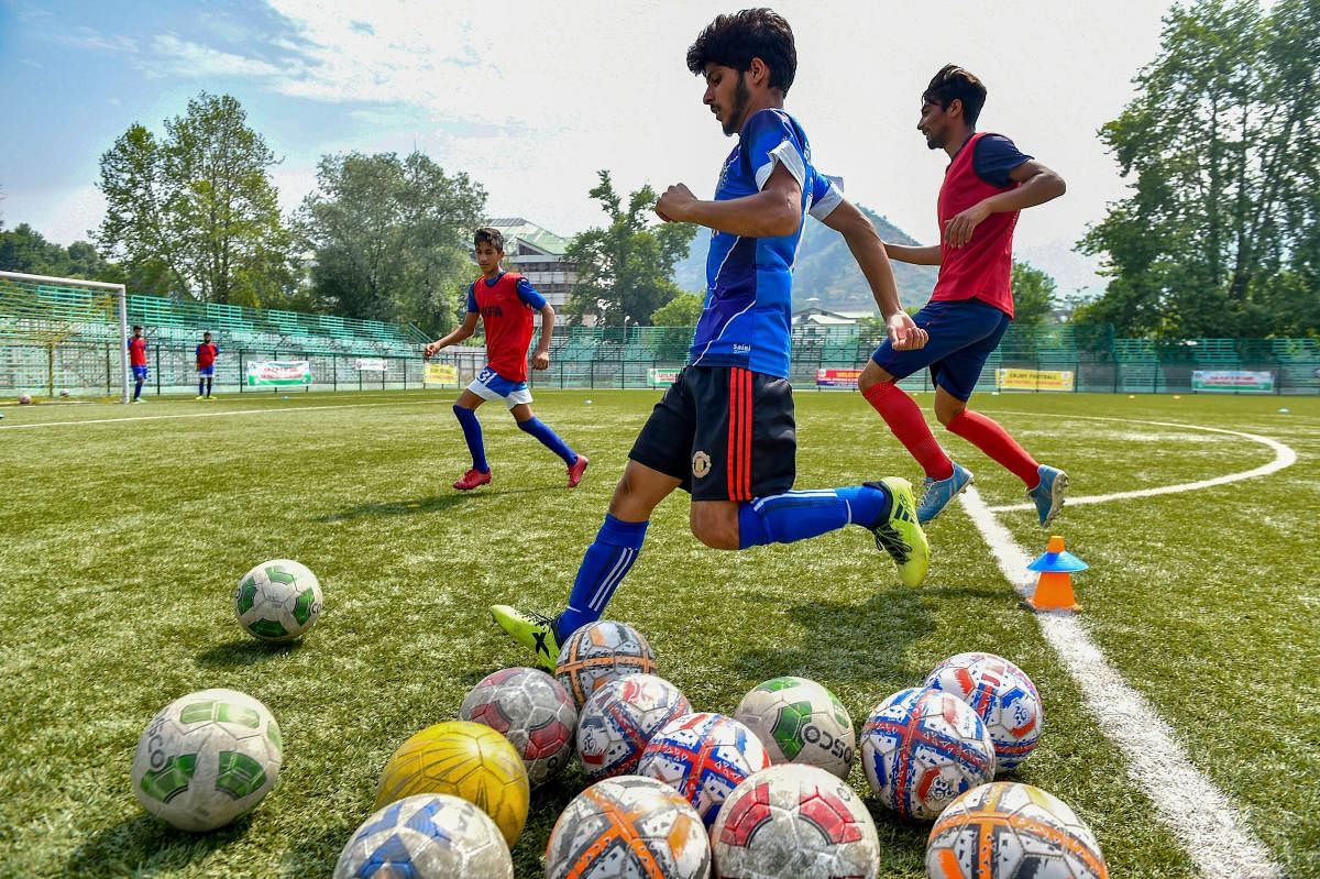 A football enthusiast kicks a football during a practice match as FIFA fever grips various parts of the country, in Srinagar. PTI Photo