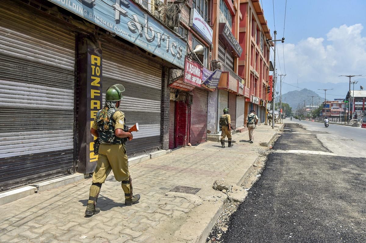 Security personnel patrol a street during a two-day strike called by the separatist leaders against the petitions in the Supreme court challenging the validity of Article 35A, in Srinagar on Sunday. PTI photo