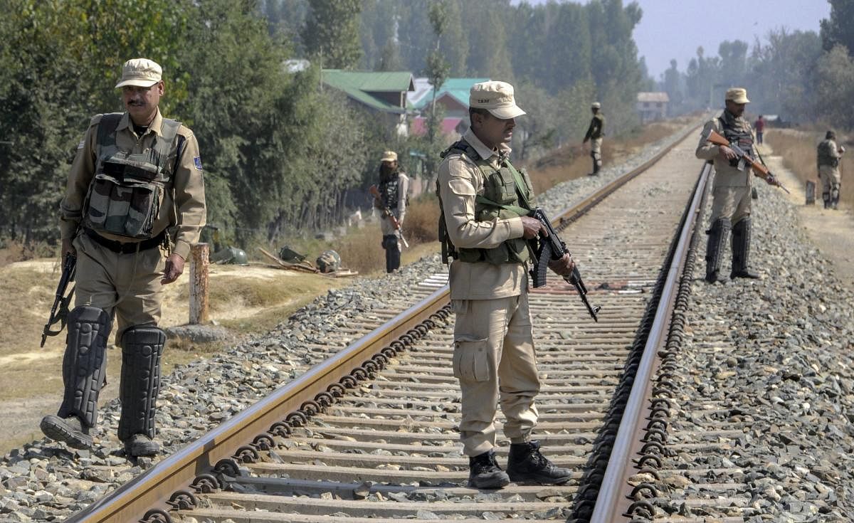 Security personnel stand guard on the railway tracks during a strike call given by the joint Hurriyat leadership against the municipal elections, in Srinagar. (PTI photo)