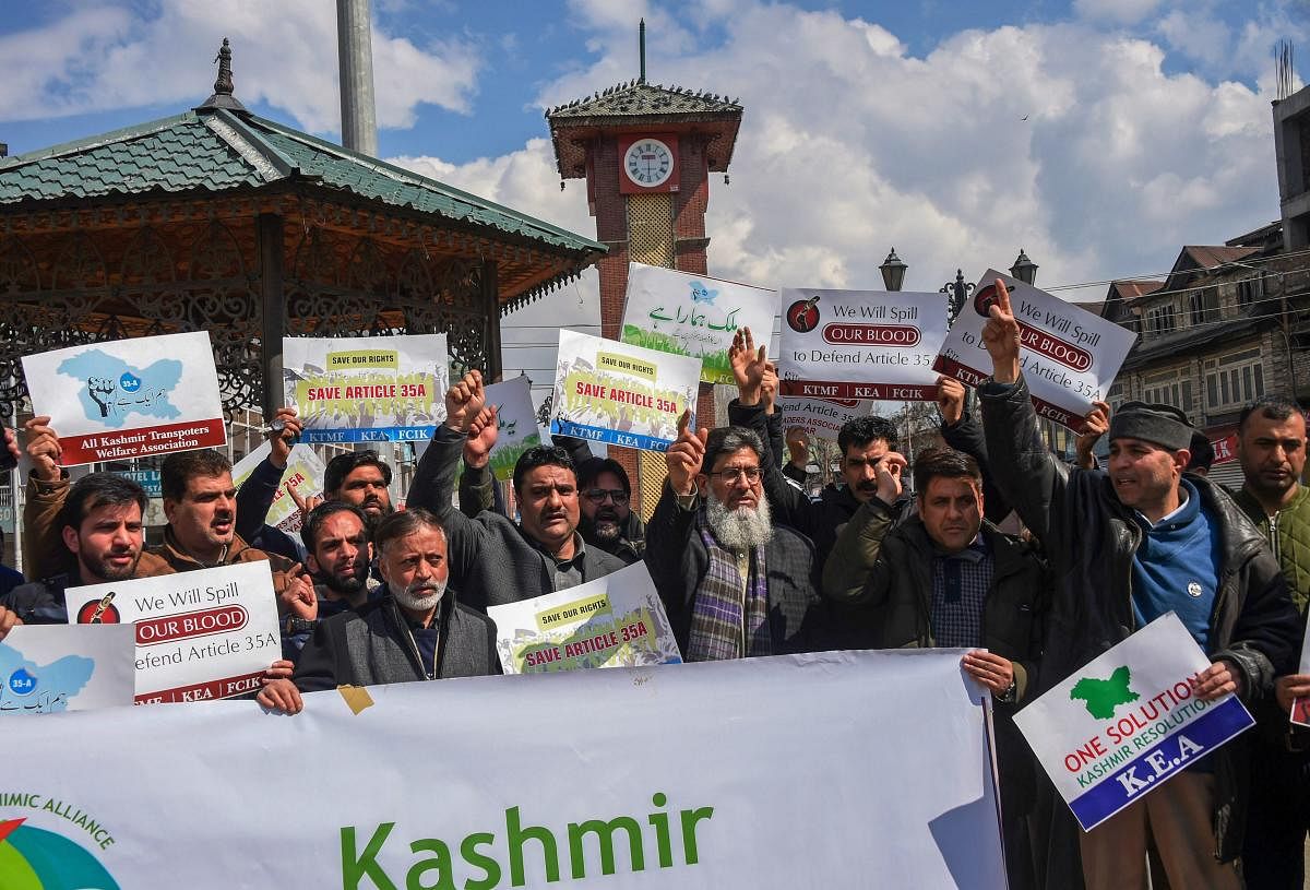 Business community members shout slogans and display placards during a strike call given by the traders in protest against extension of Central laws to Jammu and Kashmir and ban on Jamat-e-Islami, in Srinagar. PTI