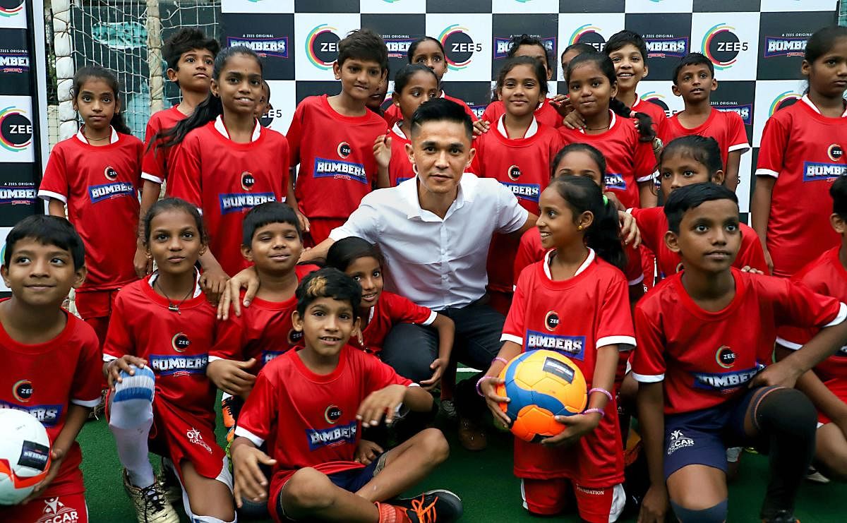 Indian footballer Sunil Chhetri poses with children at a promotional event in Mumbai, Friday, June 14, 2019. PTI
