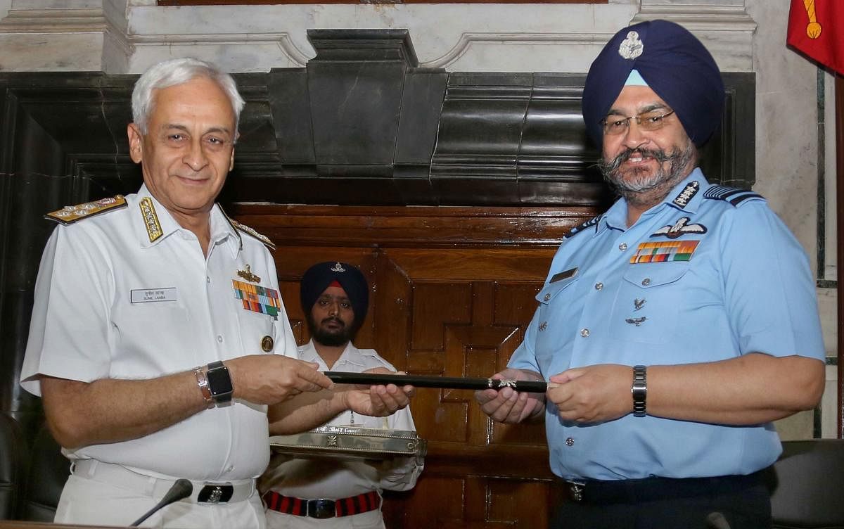 Chief of the Air Staff, Air Chief Marshal BS Dhanoa, receives the Chairman Chiefs of Staff Committee (COSC) baton from outgoing Chief of the Naval Staff Admiral Sunil Lanba in a ceremony, at South Block, in New Delhi. PTI Photo