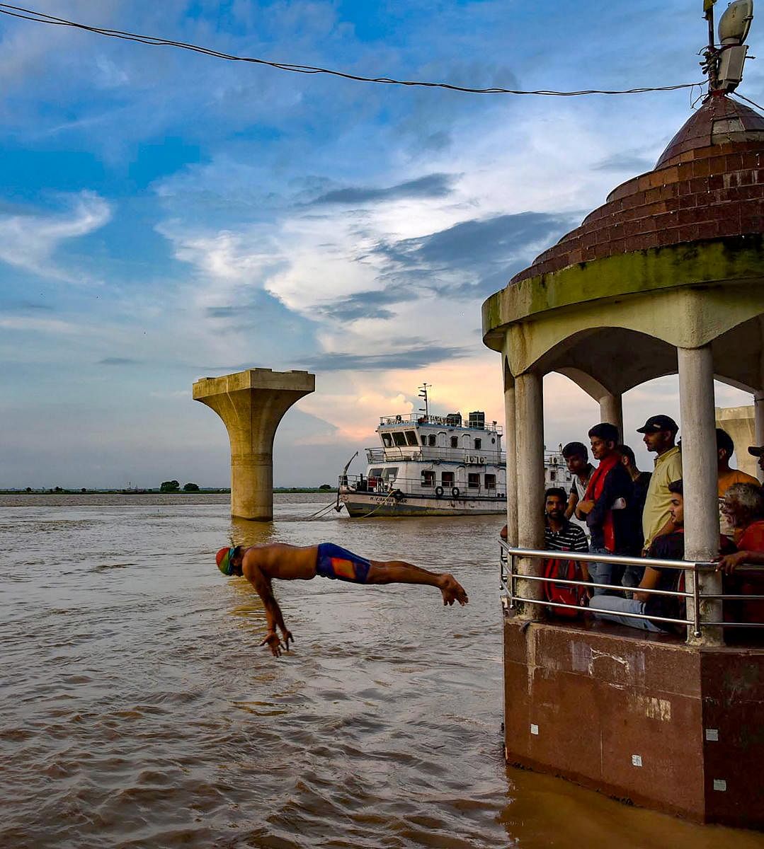 A man jumps into the swollen Ganga river at Gandhi Ghat, in Patna, Saturday, on Aug 24, 2019. (PTI Photo)