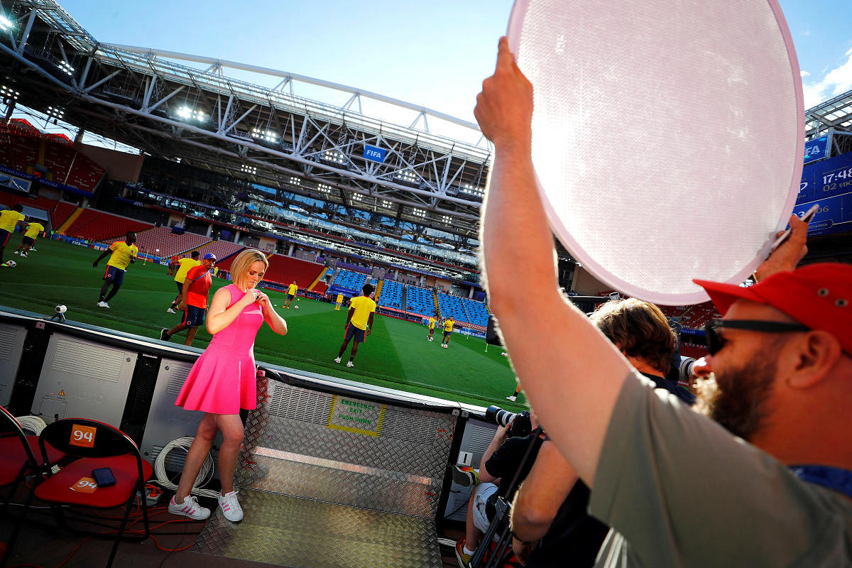A TV presenter gets ready for her live-take during a training session of Colombia at the Spartak stadium in Moscow, Russia. (Reuters Photo)