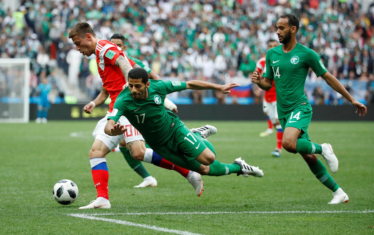 World Cup - Group A - Russia vs Saudi Arabia : Saudi Arabia's Taisir Al-Jassim and Saudi Arabia's Abdullah Otayf in action with Russia's Fyodor Smolov in Luzhniki Stadium, Moscow, Russia. REUTERS