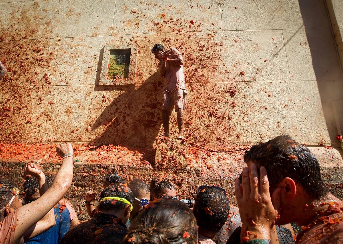 Revellers covered in tomato pulp take part in the annual