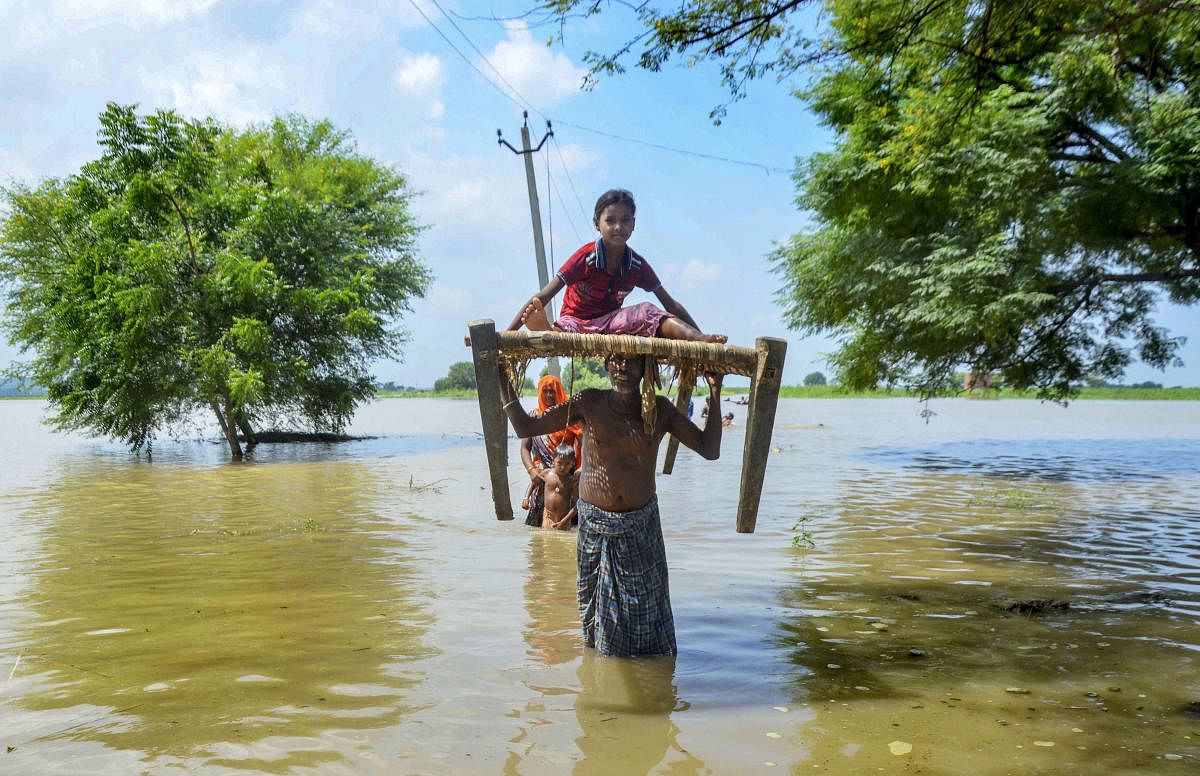 Villagers relocate to a safer place after their houses get flooded due to rise of River Ganga following monsoon rainfall, at Narsinghpur village in Mirzapur, Monday, Sept. 16, 2019. (PTI Photo)