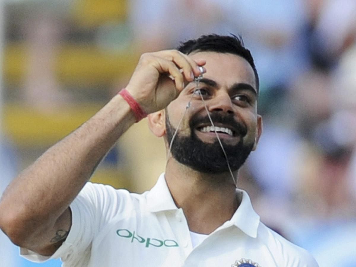 Indian cricket captain Virat Kohli holds up his wedding ring as he celebrates scoring a century during the second day of the first test cricket match between England and India at Edgbaston in Birmingham, England. AP/PTI Photo