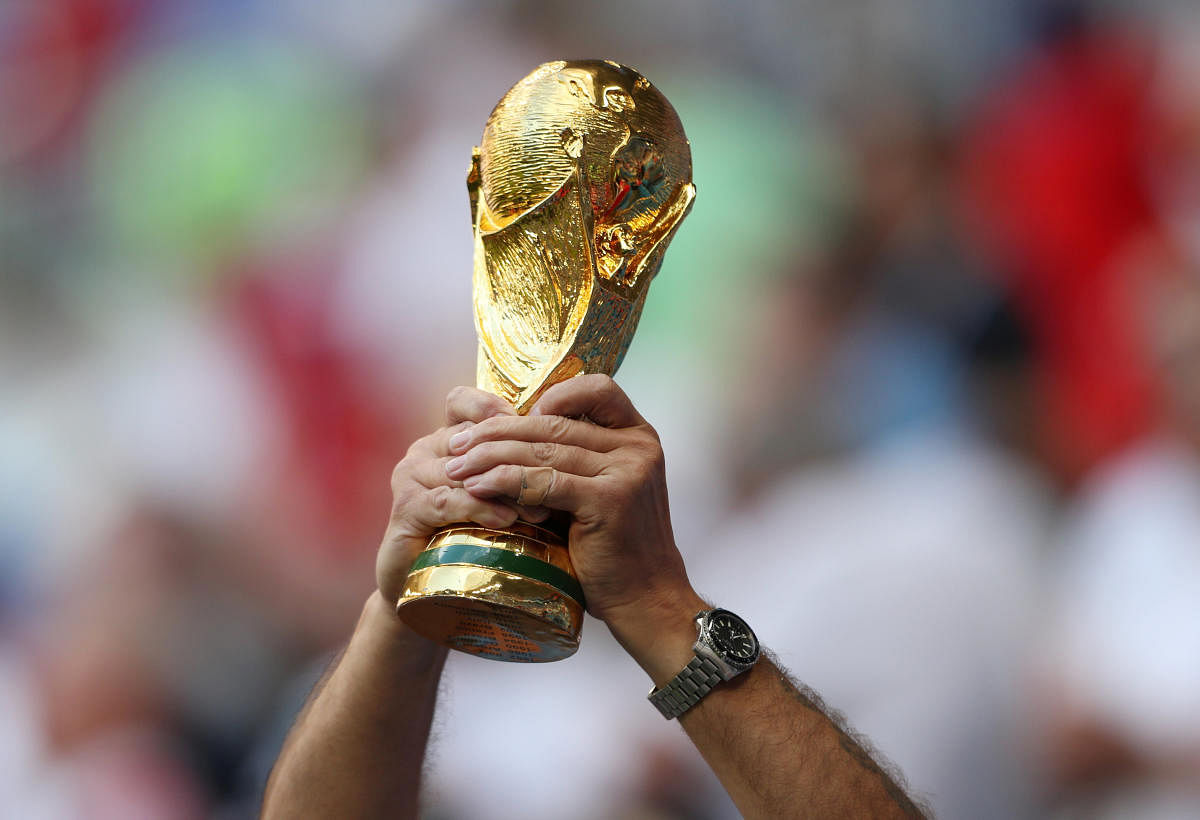 A fan holds a World Cup replica inside the stadium before the match. Reuters photo