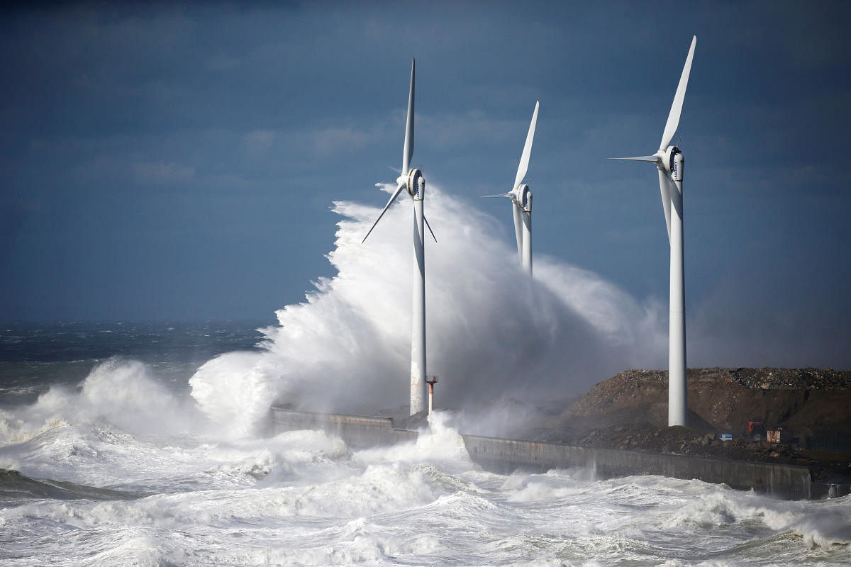 Waves crash against power-generating windmill turbines during a windy day in Boulogne-sur-Mer, France, March 10, 2019. REUTERS/Pascal Rossignol