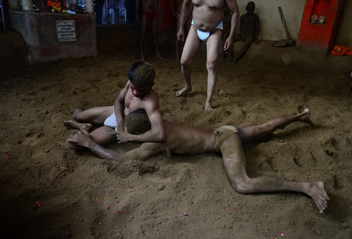 Indian wrestlers take part in a bout of traditional wrestling at the Loknath Vyayamsala wrestling club to mark the Nag Panchami festival, in Allahabad (AFP Photo)