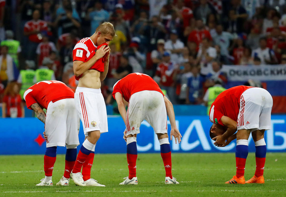 Russia's Yury Gazinsky and team mates look dejected after losing the penalty shootout. REUTERS