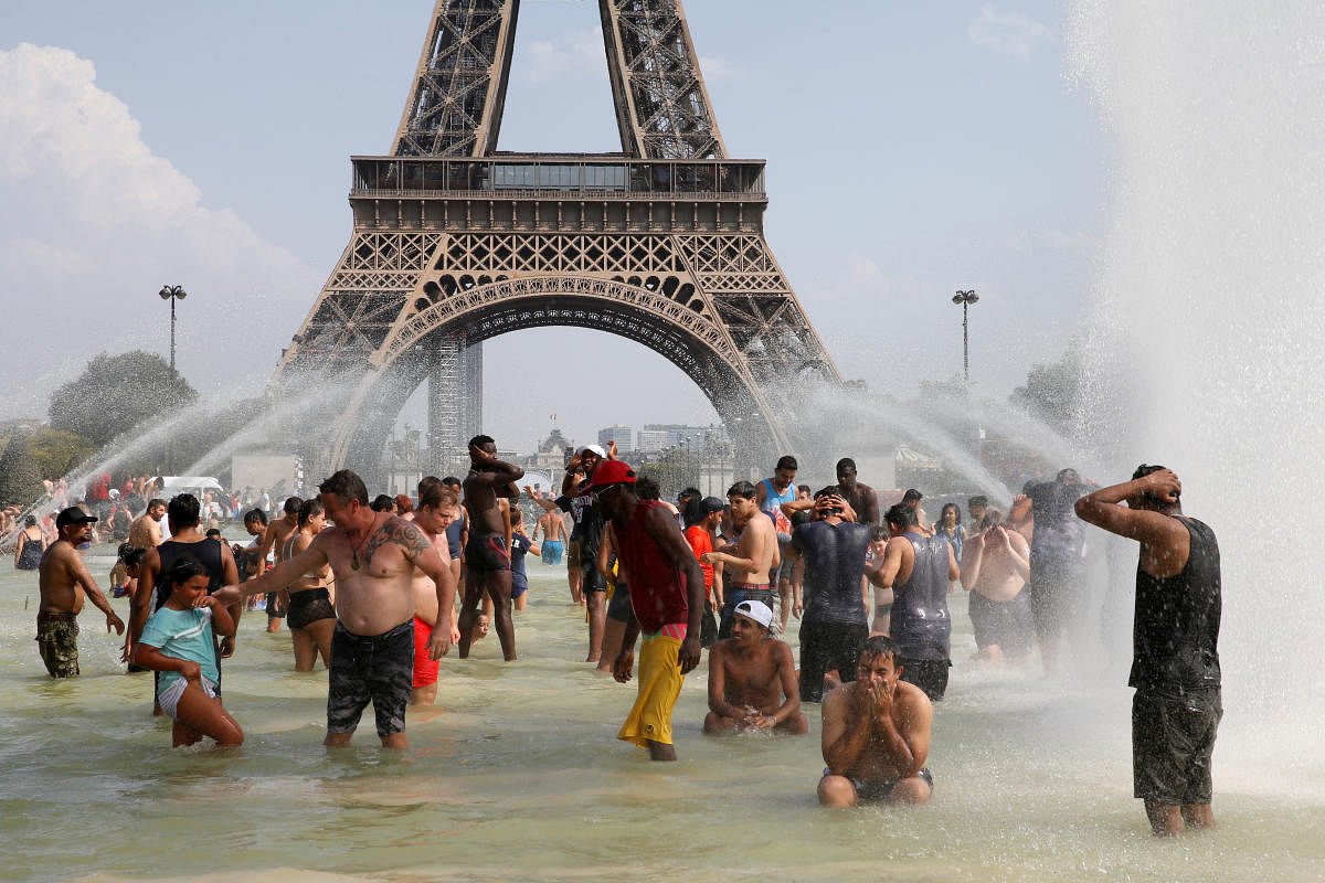 People cool off in the Trocadero fountains across from the Eiffel Tower in Paris as a new heatwave broke temperature records in France. (Reuters Photo)