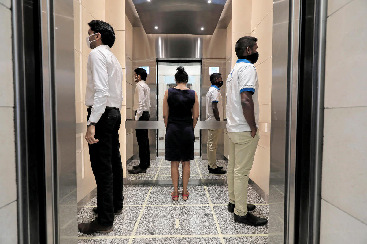 People practice social distancing inside an elevator prior to arriving to their work places at World Trade Center, after the government announced that private and state companies will reopen their offices after almost two months of lockdown amidst concerns about the spread of coronavirus disease (COVID-19) in Colombo, Sri Lanka. Credit: Reuters Photo