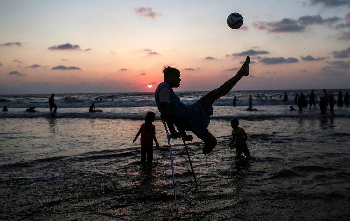 Palestinian amputees Mohammed Eliwa, 17, who lost his leg during clashes on the border with Israel, plays football on the beach in Gaza City on August 20, 2019. (Photo by AFP)