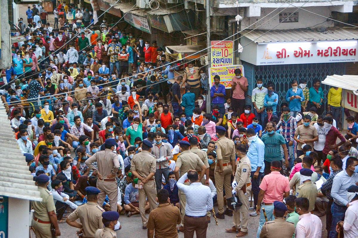 Police stops migrant workers gathered in large number demanding to go back to their native places after the announcement of nationwide lockdown got extended, in wake of the coronavirus pandemic, in Surat, Tuesday, April 14, 2020. (PTI Photo)