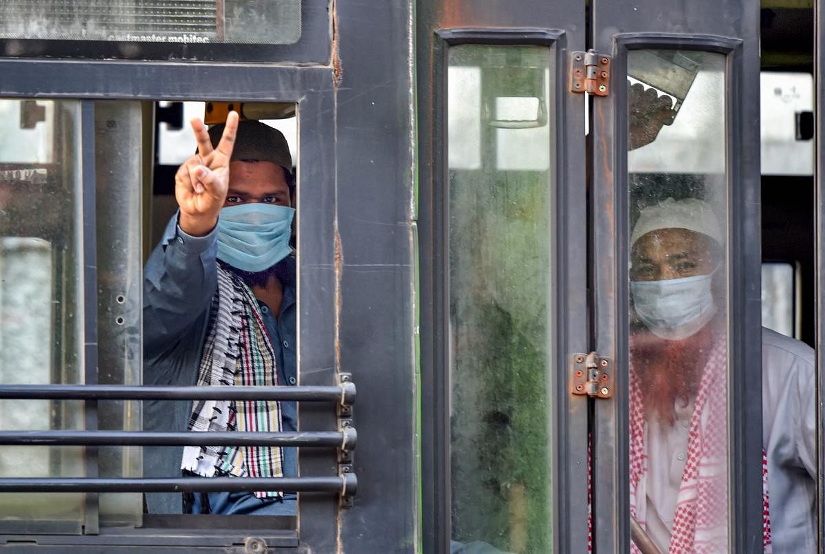 A member of the Tablighi Jamaat shows the victory sign as he leaves in a bus from LNJP hospital for the quarantine centre during the nationwide lockdown, in wake of the coronavirus pandemic, in New Delhi, Tuesday, April 21, 2020. (PTI Photo)