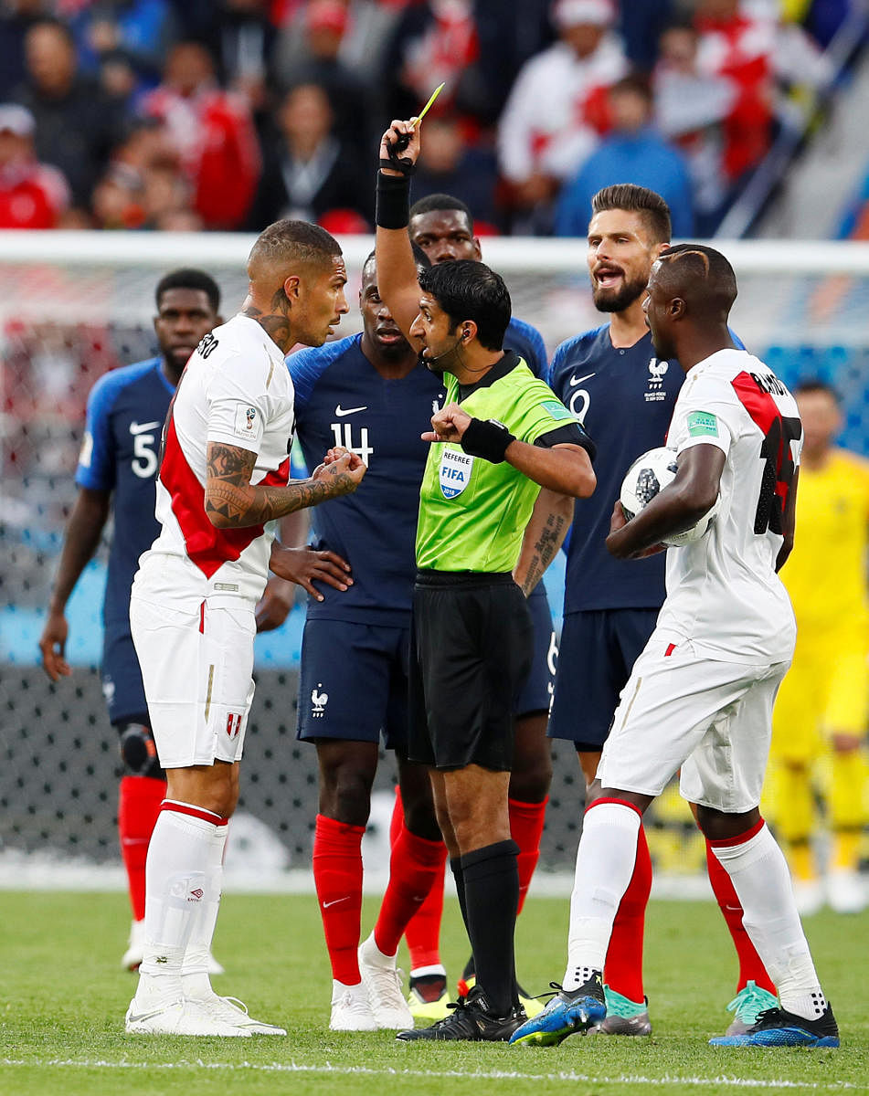 Peru's Paolo Guerrero is shown a yellow card by referee Mohammed Abdulla Hassan Mohamed REUTERS