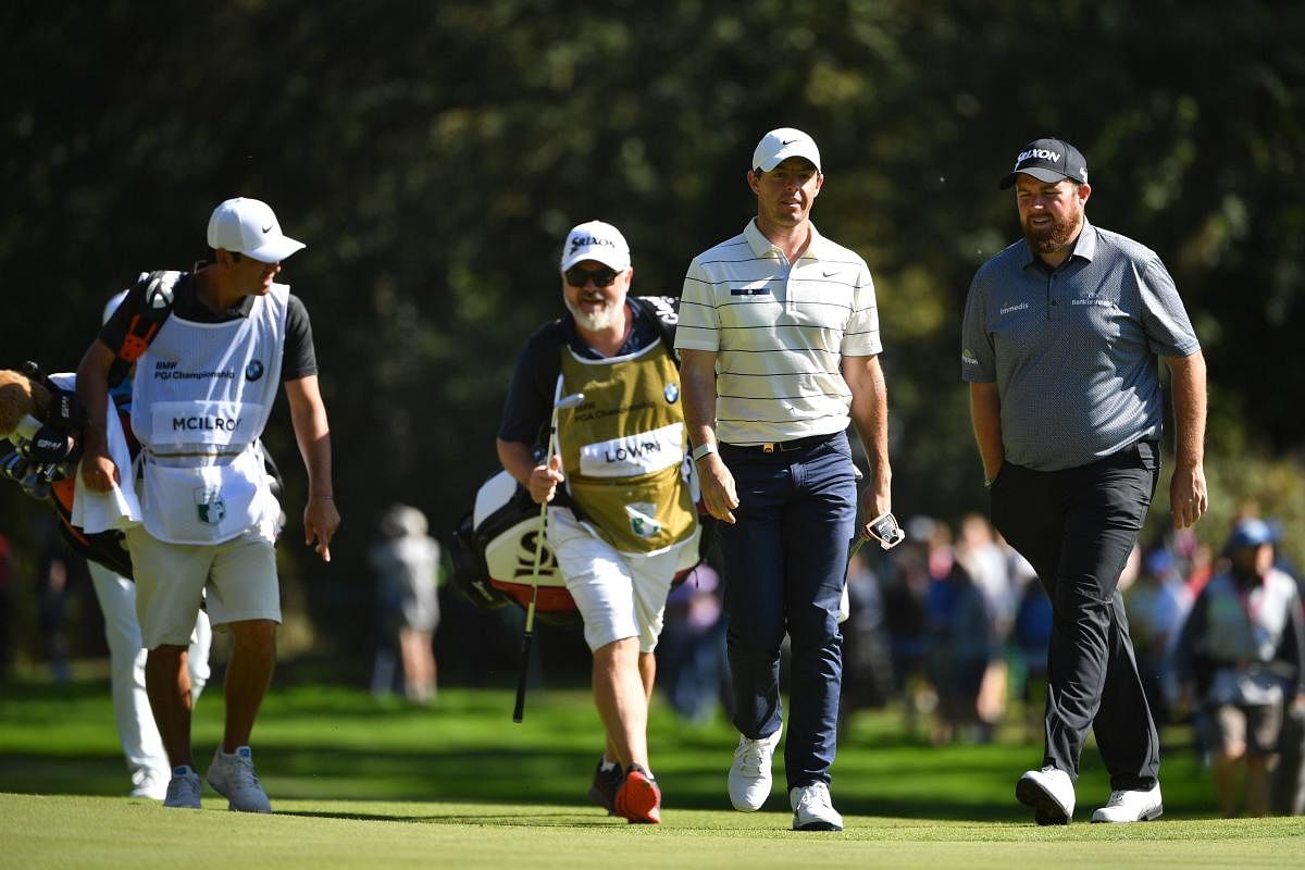 Northern Ireland's Rory McIlroy (2R) and Ireland's Shane Lowry (R) walk on the 6th on Day 2 of the golf PGA Championship at Wentworth Golf Club in Surrey, south west of London, on September 20, 2019. (Photo by Paul ELLIS / AFP)